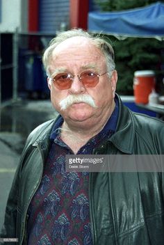 an older man wearing sunglasses and a leather jacket