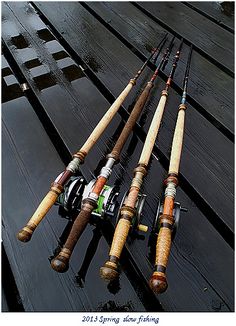 four different types of fishing rods sitting on top of a wooden table next to each other