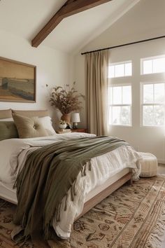 a bedroom with a large bed and wooden beams in the ceiling, along with an area rug on the floor