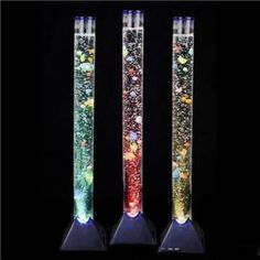 three tall glass tubes filled with different colored liquid