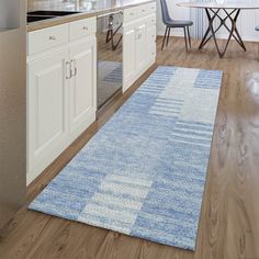 a kitchen with white cabinets and blue rug