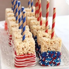 rice krispy treats are arranged on a white plate with red, white and blue straws