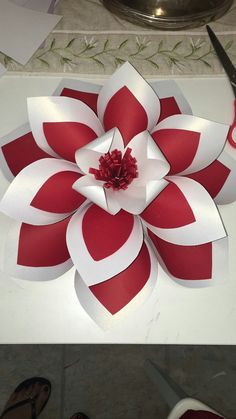 two pictures with red and white paper flowers on them, one is cut out to look like an origami flower