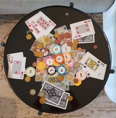 a black table topped with lots of different types of cards and chips on top of it