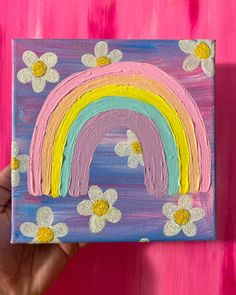 a painting with flowers and a rainbow painted on it