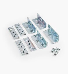 an assortment of metal brackets and screws on a white background