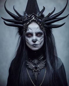 a woman with black makeup and horns on her head