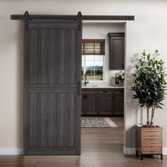 an open door leading to a kitchen with wood floors and brown cabinetry in the background