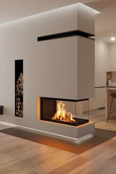 a modern fireplace in the middle of a living room with wood flooring and white walls