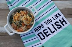 a bowl of food sitting on top of a blue and white towel next to a napkin