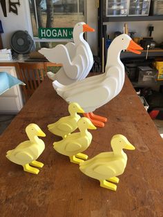 three ducks and one duckling are sitting on a table