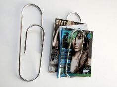 a pair of scissors and magazine clips on a white surface