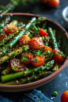 Roasted asparagus and cherry tomatoes garnished with chopped green onions and pepper in a bowl. Asparagus Recipes Stove Top, Recipes Stove Top, Sautéed Asparagus