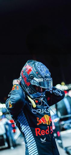 a man wearing a red bull racing suit and helmet