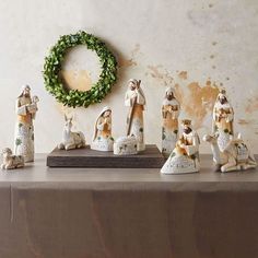 a group of figurines sitting on top of a table next to a wreath