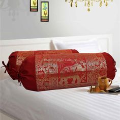 a red bag sitting on top of a white bed