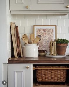 a kitchen counter with wooden utensils on it and a basket in the corner