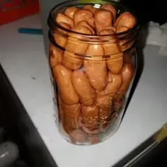 a glass jar filled with peanuts sitting on top of a counter