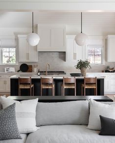 a living room filled with furniture next to a kitchen