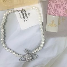 "Brand New, Never Used, With Box And Dust Bag Fuax Pearls/ Pave Set Swarovski Crystals, Comes With Original Eco Friendly Vivienne Westwood Packaging! In Great Condition! Faux Pearl Bas Relief Necklace. Approx Longth 20” Saturn It Is Large, Approx 2.5” Long X 1.5” H." Star Vivienne Westwood, Red Vivienne Westwood Jewelry, Vivian Westwood Necklace Outfit, Red Vivienne Westwood Necklace, Vienne Westwood Jewelry, Designer White Necklaces For Gifts, Westwood Pearl Necklace, Vivienne Westwood Pearl Necklace, Jewelry Vivienne Westwood