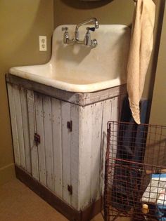 a bathroom sink sitting under a mirror next to a basket filled with towels and other items