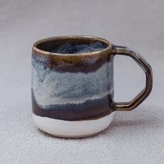 a coffee cup sitting on top of a white carpeted floor next to a wall