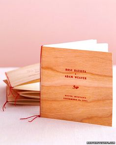 a stack of wooden business cards sitting on top of each other next to a pink wall