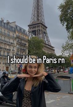 a woman standing in front of the eiffel tower with her hand on her head