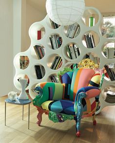 a colorful chair sitting in front of a book shelf filled with books