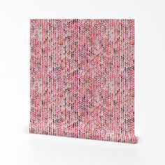 a close up of a piece of cloth on a white surface with pink and red colors