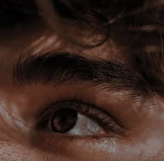 a man's eye is shown with the reflection of his hair on it and in front of him