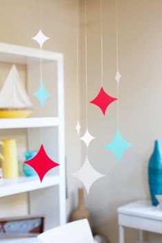 some red and blue stars hanging from the ceiling in a child's playroom