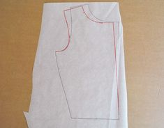 a piece of white paper with red stitching on it