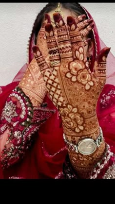 a woman with her hands on her face covered in henna and holding it up