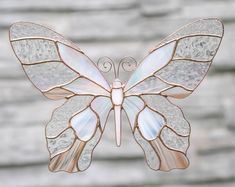 a stained glass butterfly hanging on a brick wall