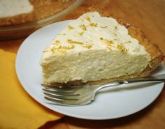 a piece of cheesecake on a plate with a fork next to the rest of the pie