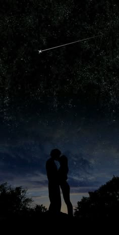 a couple kissing under the stars in the night sky