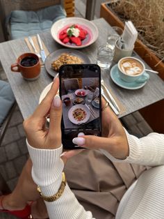 a woman taking a photo of food on her phone