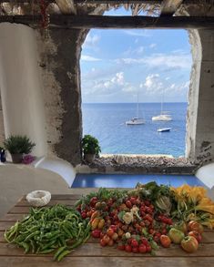 a wooden table topped with lots of veggies on top of a blue floor