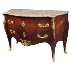 an ornately decorated chest with gold trimmings and floral designs on the drawers