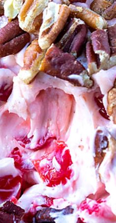 a close up view of some fruit and nuts on top of ice cream with cranberry sauce