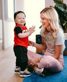 a woman is playing with a child on the floor