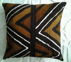 a brown and black pillow sitting on top of a bed