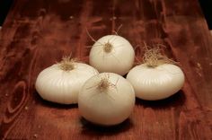 three onions are sitting on a cutting board