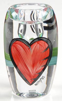 a glass vase with a red heart painted on it