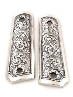 two silver door handles with intricate designs on each one and the other side is open