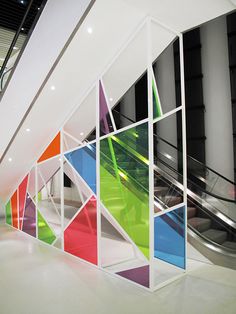 an artisticly designed wall in a building with colorful glass panels on it's sides