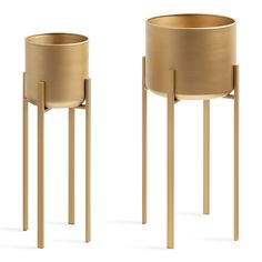 two gold planters sitting next to each other on top of wooden legs, one in the shape of a pot