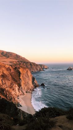 the ocean is next to some rocky cliffs