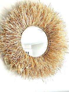 a circular mirror with some straw on it